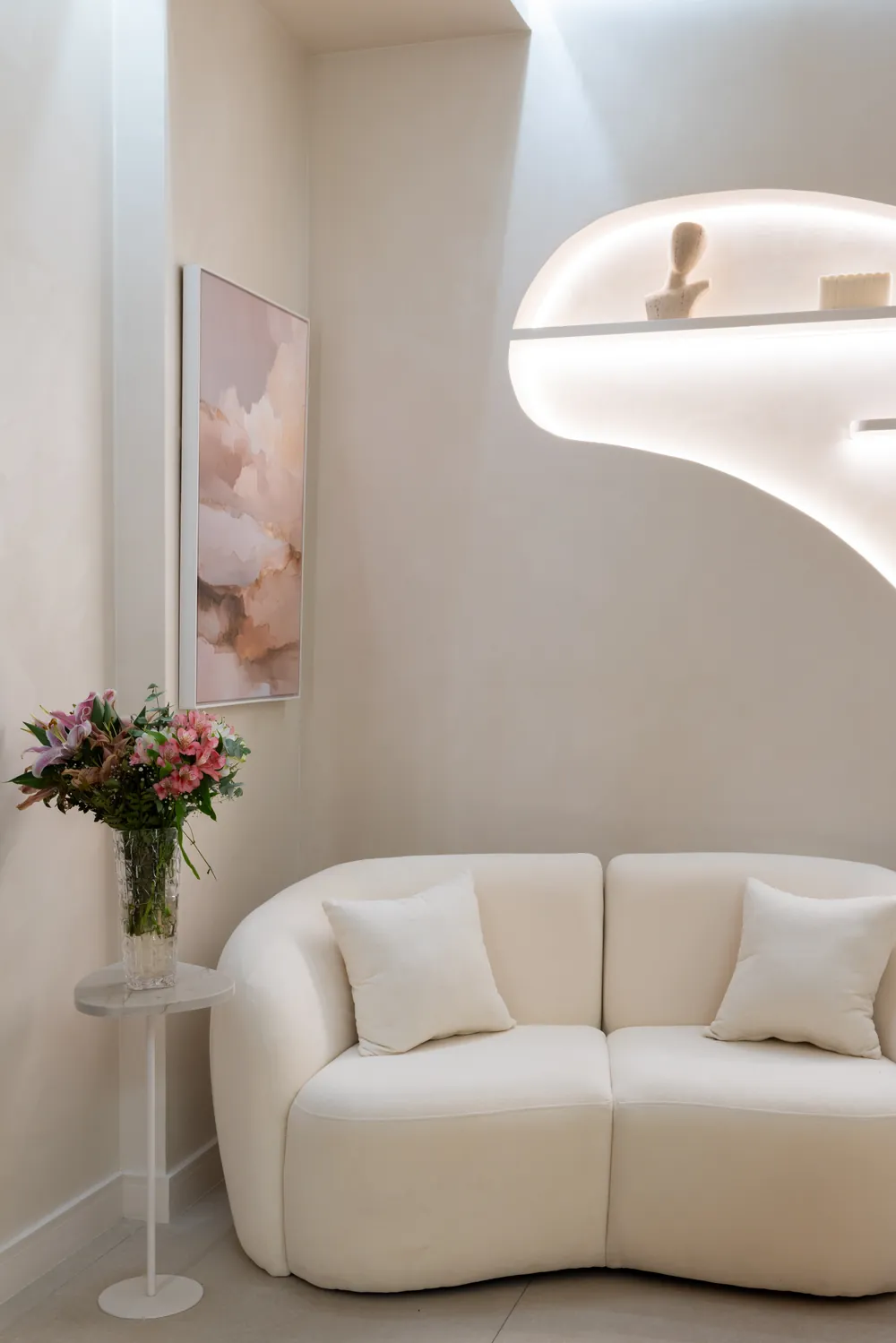 Sala de espera da Elésis com sofá creme e flores